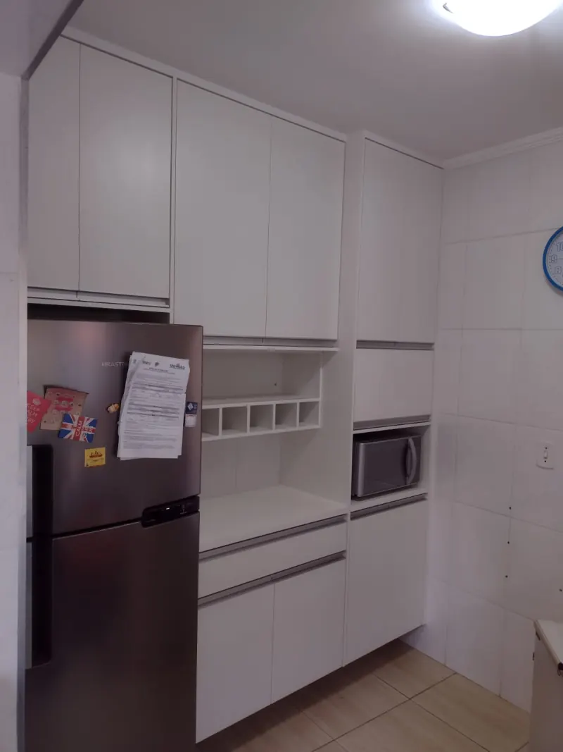 Cozinha planejada branca em MDF com armários aéreos até o teto, nichos, espaço para micro-ondas e gaveteiros