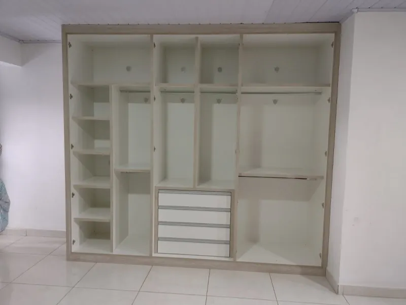 Interior de guarda-roupa planejado mostrando prateleiras, cabideiros, sapateira e gaveteiro de quatro gavetas